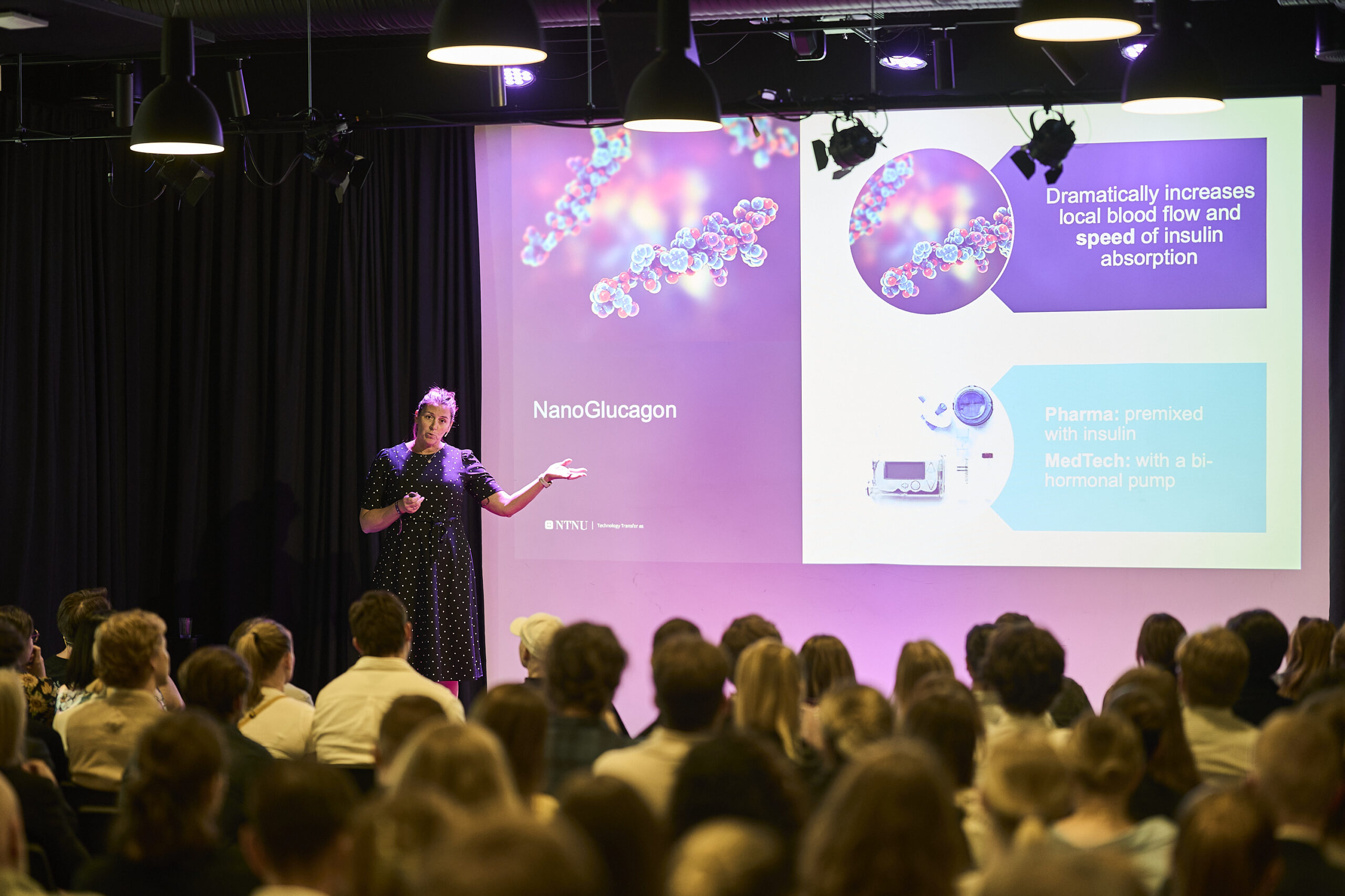 _DSD1021_WEB Hilde Kjelstad Berg er forretningsutvikler i Nano Glucagon fra NTNU TTO og presenterer prosjektet på skjerm foran et stort publikum.